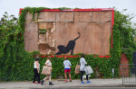 London, UK. 10th August 2024. Crowds gather around a new artwork by Banksy on an old billboard in Cricklewood. The artwork, depicting a wild cat like a tiger or leopard, is the sixth new artwork in as many days in London by the elusive street artist. Cred