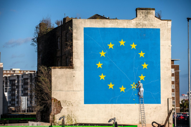 A mural by graffiti artist Banksy depicting a worker chiselling away a star representing the UK on an EU flag following Brexit in Dover, Kent, UK.