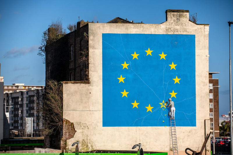 A mural by graffiti artist Banksy depicting a worker chiselling away a star representing the UK on an EU flag following Brexit in Dover, Kent, UK.