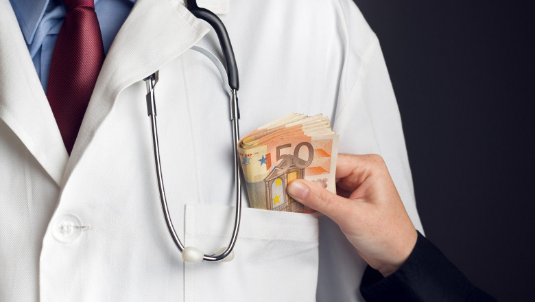 Corruption in Health Care Industry, Doctor receiving large amount of Euro banknotes as a bribe.