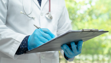 Doctor checking and note diagnosis medicine in clipboard of pati