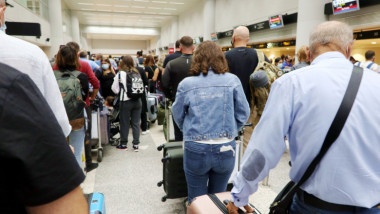 oameni la o coada pe aeroport