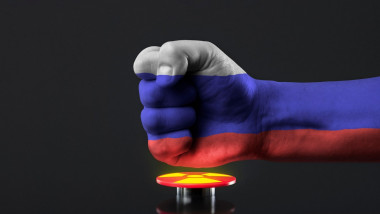 The threat of nuclear war. Russia threatens the world with nuclear weapons. A fist painted in the colors of the Russian flag presses a large red