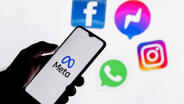 Facebook changes its name to Meta. Smartphone with Meta logo on the background on logos of products owned by facebook metaverse.