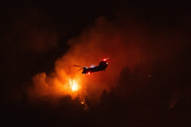 LOS ANGELES, CA - SEPTEMBER 08: A water-dropping helicopter battles the Line Fire growing on September 8, 2024 in San Be