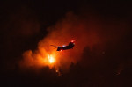 LOS ANGELES, CA - SEPTEMBER 08: A water-dropping helicopter battles the Line Fire growing on September 8, 2024 in San Be