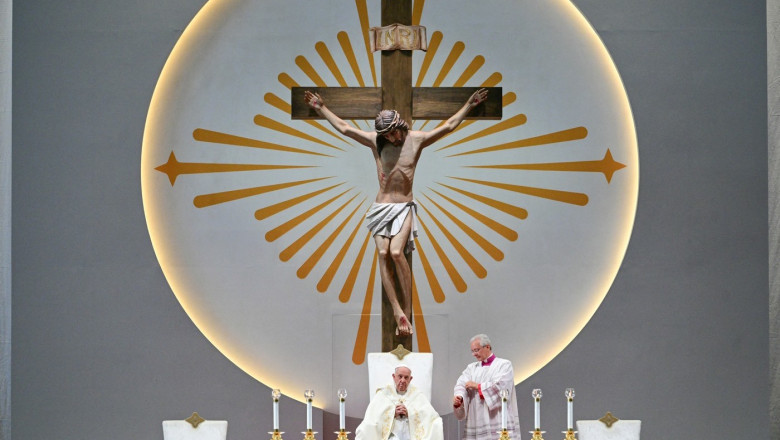 Pope Francis (L) leads a holy mass at the National Stadium in Singapore, with a giant jesus statue above