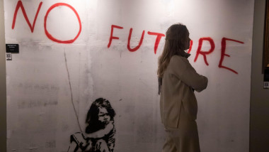 Moscow, Russia. 10th of February, 2024. A woman stands before "No Future" painting on display during an exhibition dedicated to English-based street artist Banksy, in Moscow, Russia. Titled "Find Banksy" and held at VDNKH Pavilion No 21, it contains copie