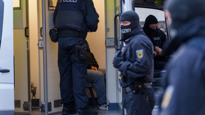 Mannheim, Germany. 24th Sep, 2024. A police officer speaks in a cell car with a man suspected of not having a valid residence permit for Germany during a raid for smuggling of migrants. Credit: Andreas Arnold/dpa/Alamy Live News