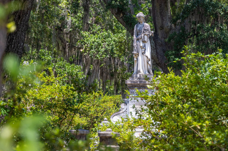 Grave monument statue of a woman amidst Spanish moss draped Southern live oaks at historic Bonaventure Cemetery in Savannah, Georgia. (USA)