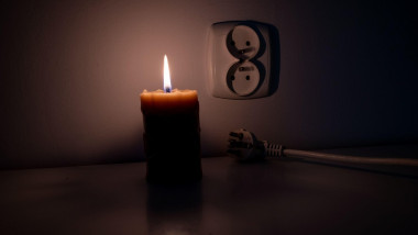 Blackout, candle with a socket, power cut - no electricity, the flame of a candle, circuit breaker, electrical outlet plug