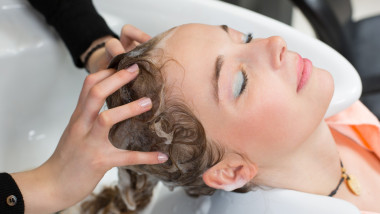 hairdresser washing customers hair in salon