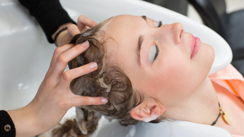 hairdresser washing customers hair in salon