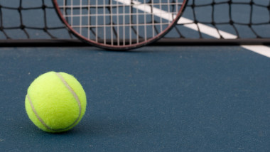 Tennis,Ball,,With,Racquet,And,Tennis,Net,In,Background