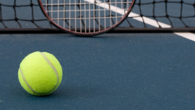 Tennis,Ball,,With,Racquet,And,Tennis,Net,In,Background