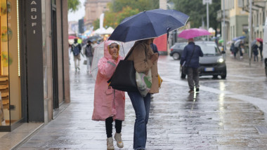 oameni cu umbrele si pelerine, ploaie de toamna