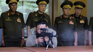 Kim Jong Un (C) test-firing a sniper weapon developed by the Academy of Defence Sciences