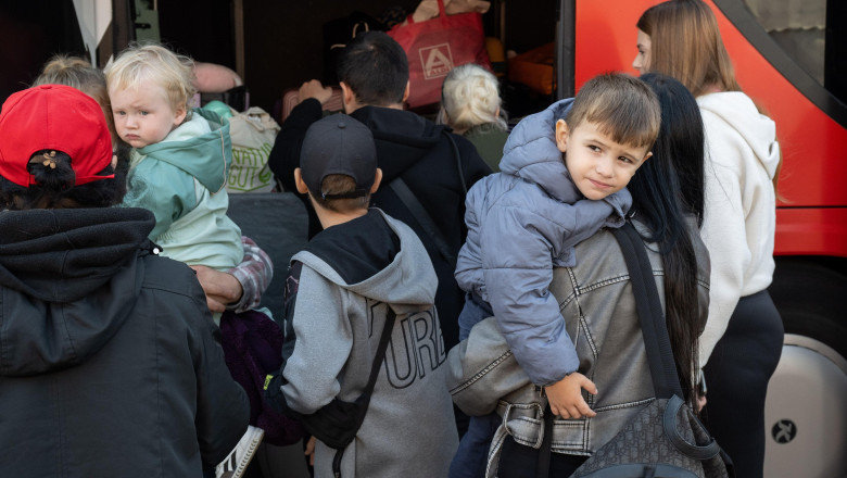 18 September 2024, Hesse, Gieen: Refugees from Ukraine stand by a bus at the initial reception center for refugees in Hesse. From here, the people are distributed to the municipalities within the state. Photo: Boris Roessler/dpa