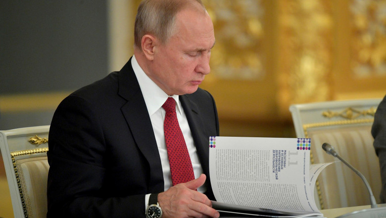 Russian President Vladimir Putin reads a report during a State Council meeting on the development of the volunteer movement and non-profit organizations at the Kremlin December 27, 2018 in Moscow, Russia.