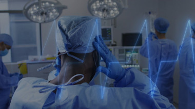 Medical team in operating room with heartbeat image over scene