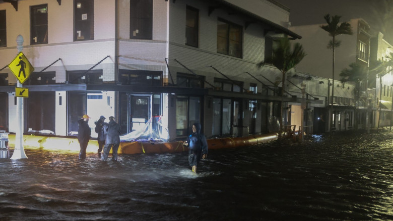 Members of the media work in flooded streets after Hurricane Milton made landfall in the Sarasota area