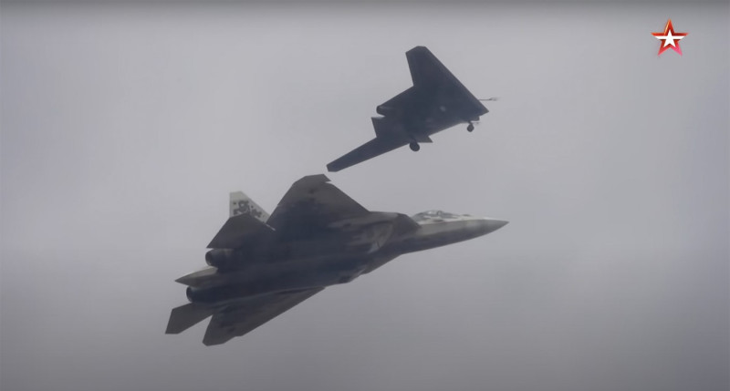S-70 Okhotnik drone pictured along Su-57 fighter jet during a flight.