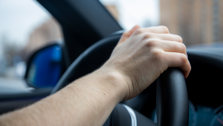 Unrecognizable,Person,Holds,Her,Right,Hand,On,The,Steering,Wheel