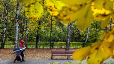 A mother and child walk in an autumn Park in Moscow during a rain, Russia