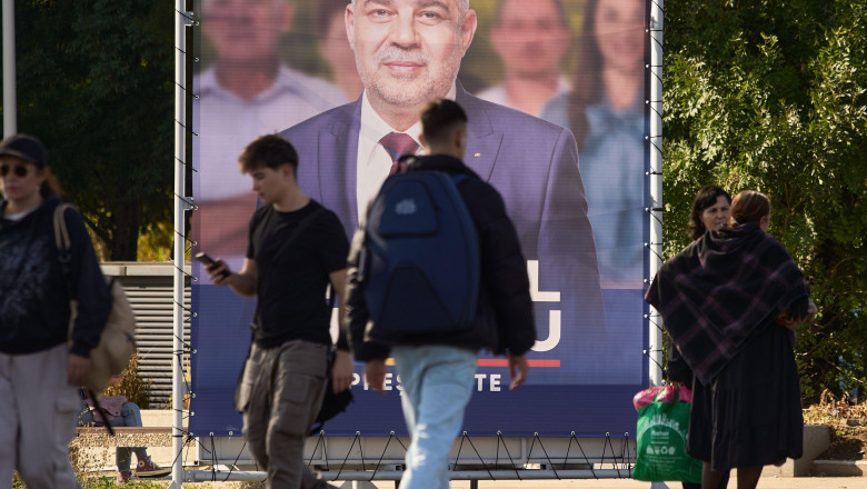 Bucharest, Romania. 1st Oct, 2024: People walk past a large banner from the presidential election campaign of Marcel Ciolacu, president of Social Democratic Party (PSD) and Romanian prime minister. Credit: Lucian Alecu/Alamy Live New