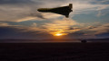 A Russian military drone flying over a peaceful field, evening lighting.