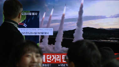 A man watches a television showing a news broadcast with file footage of a North Korean missile test, at a railway station in Seoul