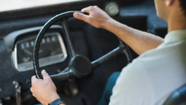 Mid-section of bus driver driving a bus