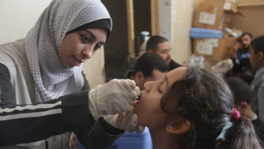 A Palestinian child receives a dose of polio vaccine at a UN-run school in Gaza City