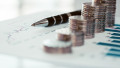 Stack of coins with line chart and bar graph