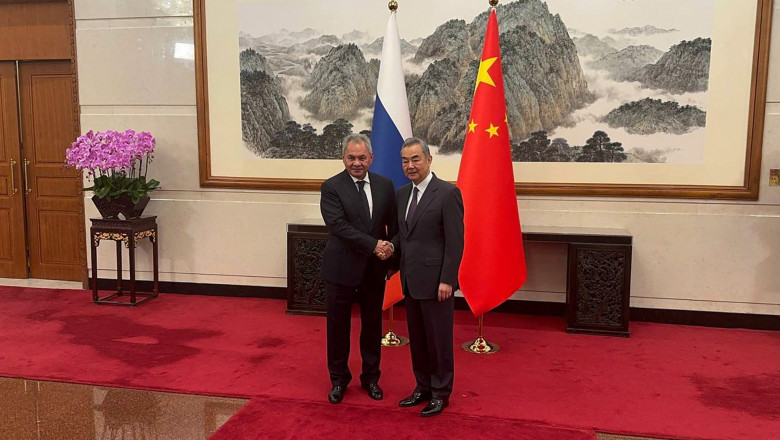 secretary of Russia's Security Council Sergei Shoigu meets with Chinese Foreign Minister Wang Yi in Beijing, shake hands