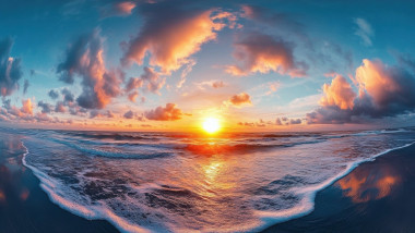 Panoramic ocean sunrise illuminating colorful clouds and gentle waves