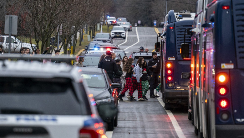 Students from Abundant Life Christian School are escorted to a city bus where they will reunited with their parents after a school shooting on December 16, 2024