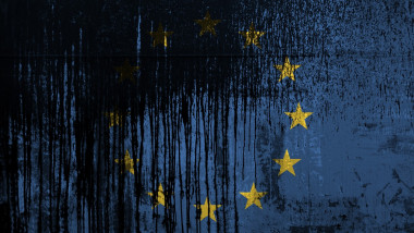 European union flag depicted in paint colors on old and dirty oil barrel wall closeup. Textured banner on rough background