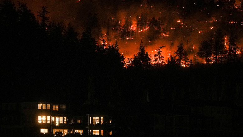 incendiu de padure in munti, noaptea, in apropiere se vede o cladire cu lumini aprinse