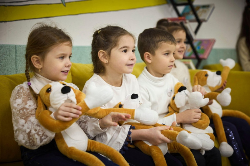 Zaporizhzhia, Ukraine. 12th Dec, 2024. Ukrainian children play with stuffed toys given them by Ukrainian President Volodymyr Zelenskyy during a visit to the first school built completely underground, December 12, 2024 in Zaporizhzhia, Zaporizhzhia Oblast,