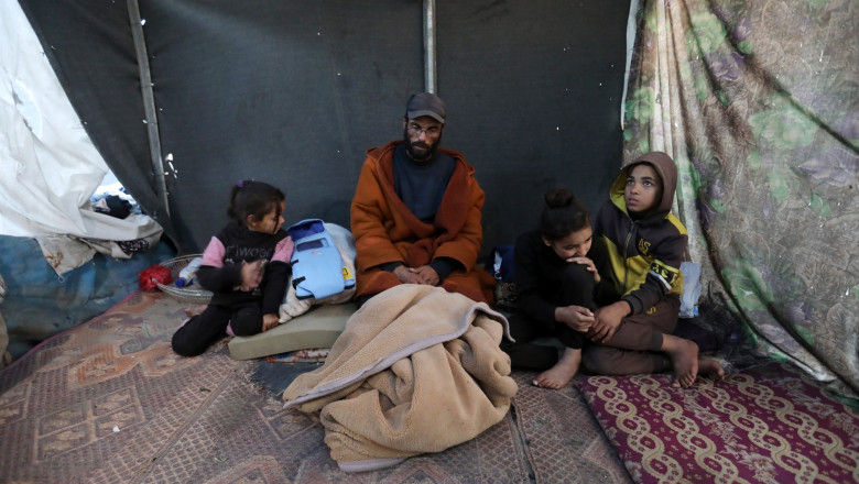 The grieving father Yahya al-Batran and his children in a tent in Gaza