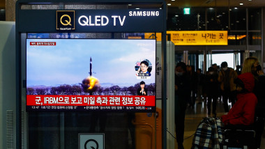 People watch a TV news report on a ballistic missile launched by North Korea