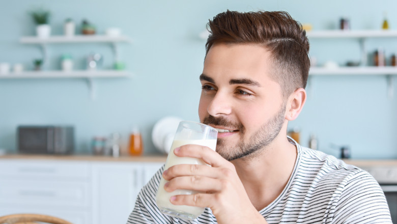 Handsome,Man,Drinking,Tasty,Milk,In,Kitchen,At,Home