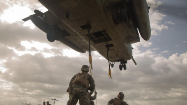 U.S. Marine Corps landing support specialists with Special Purpose Marine Air-Ground Task Force Southern Command prepare to hook a concrete block for a sling-load during a helicopter support training evolution at Soto Cano Air Base, Honduras, July 1, 201