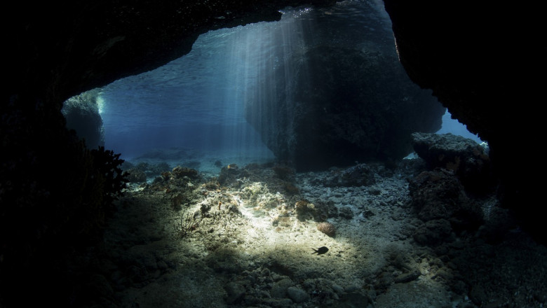 Sunlight descends into a dark cavern near Alor, Indonesia.