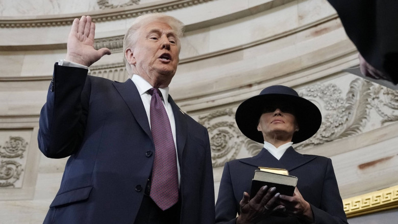 Donald Trump cu mana ridicata depune juramantul, Melania langa el cu 2 biblii in mana