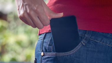 The,Woman,Puts,The,Phone,In,Her,Jeans,Pocket