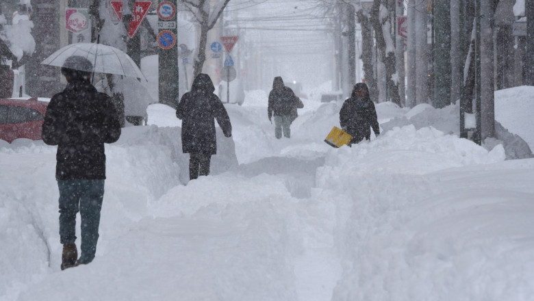 oameni care merg prin zapada in japonia