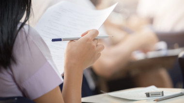 o fata care tine o foaie de examen in mana
