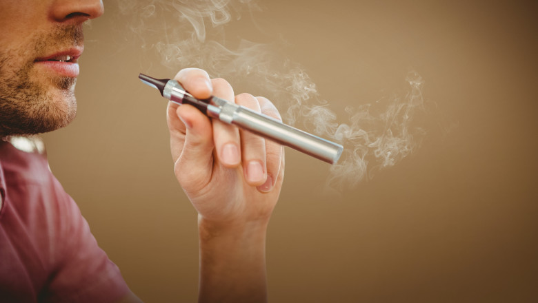 Composite image of cropped image of man smoking electronic cigarette